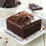 Square close-up of Midnight Fudge Cake slice with rich dark chocolate frosting and fudgy interior